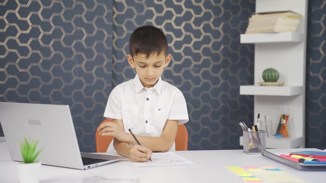 мальчик учится на ноутбуке.