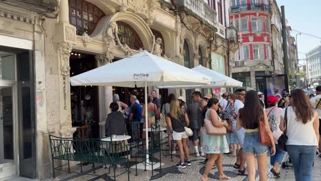 people queuing outside the historic majestic cafe in porto, portugal