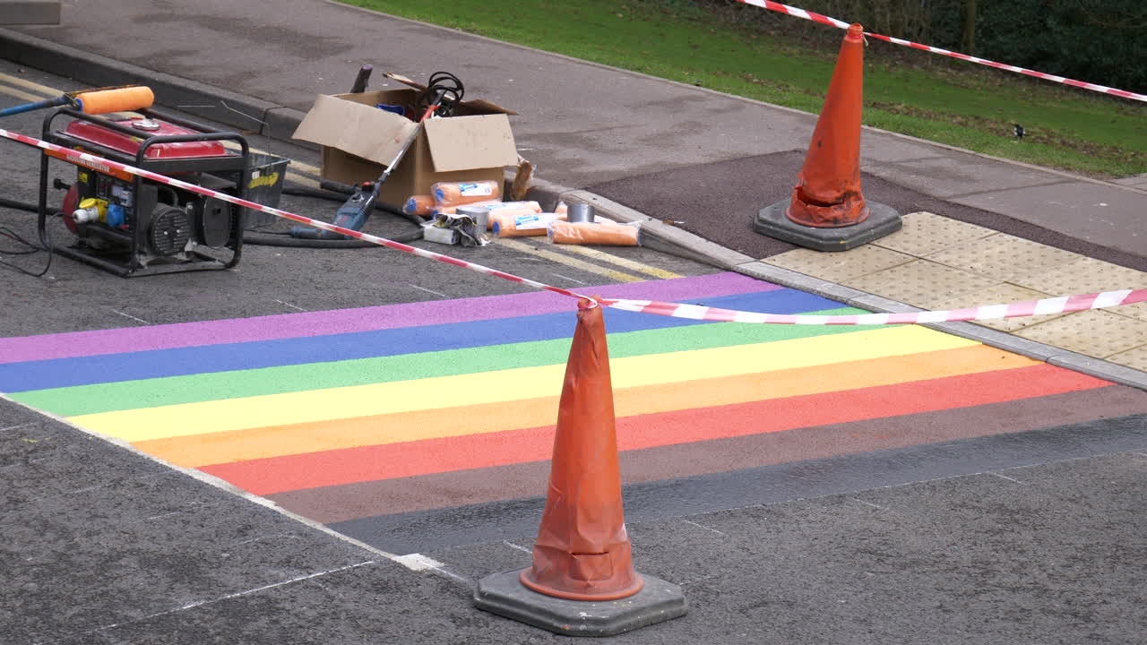 los trabajadores pintan la bandera del orgullo gay del arco iris en la carretera