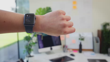 Close-Up-POV-Shot-Of-Female-Office-Worker-At-Desk-Using-Smart-Watch