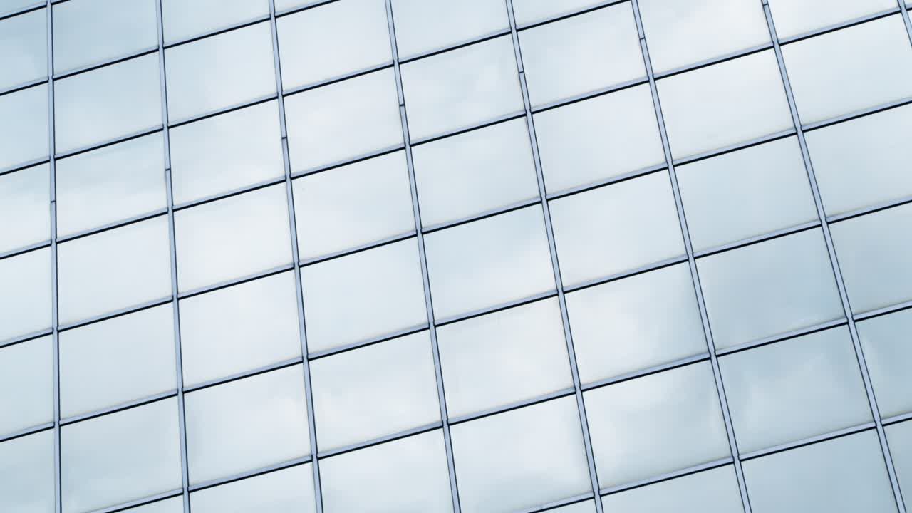 Time lapse clouds passing shiny office windows loop 4K
