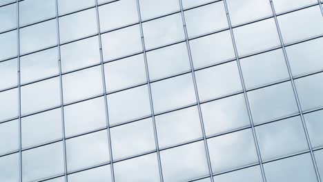 Time lapse clouds passing shiny office windows loop 4K