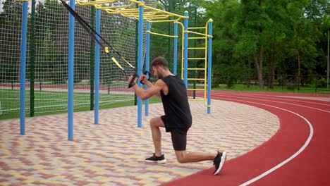 a muscular man doing legs exercise using rubber belt to force strenth of workout