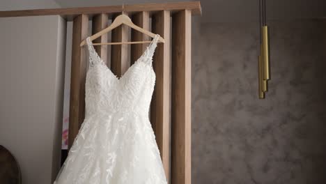 a beautiful white wedding dress hangs on a hanger in the wardrobe in the bedroom