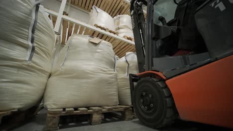 forklift loading/unloading big bags in a warehouse