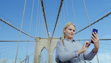 Una-Mujer-Se-Toma-Fotos-En-El-Famoso-Puente-De-Brooklyn,-Uno-De-Los-Principales-Atractivos-De-La-Nueva