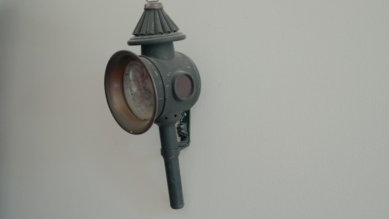 primer plano de una anticuada linterna metálica montada en una pared blanca