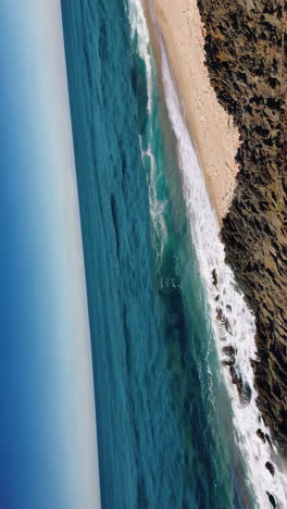 aerial view of ocean waves crashing on rocky coastline