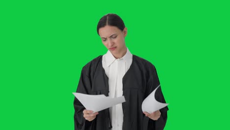 abogada india enojada leyendo archivos de casos pantalla verde