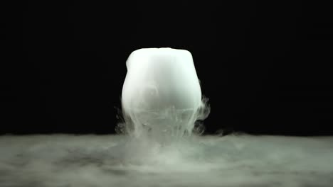 cognac glass with the effect of dry ice at black background - cognac glass with the effect of dry ice on black background at studio, chemical reaction with smoke on dark surface