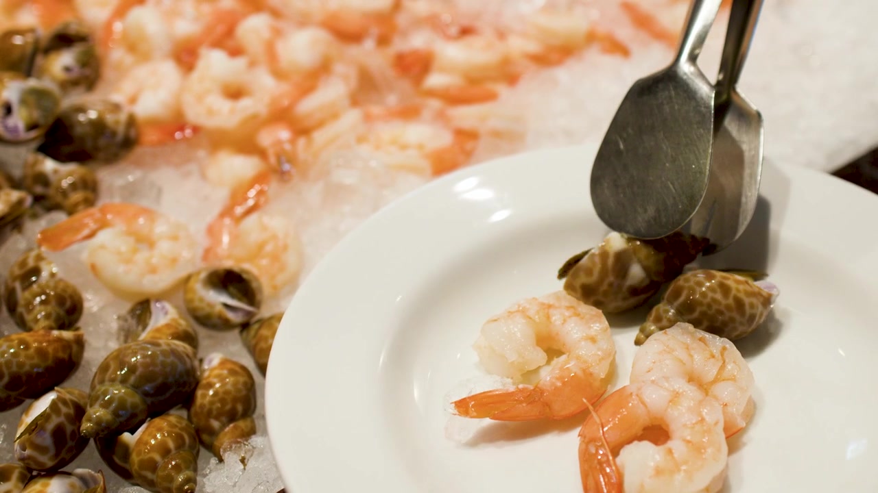 Person Using Tongs to Serve Seafood from Ice Bed