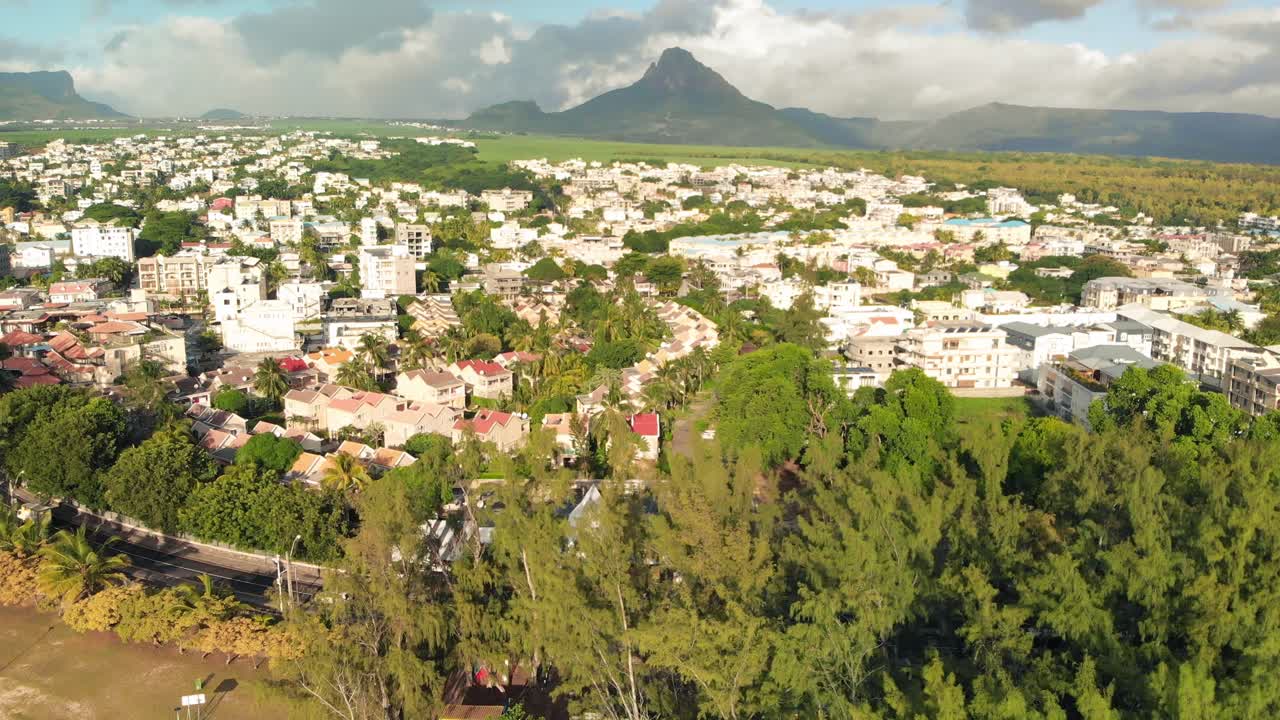 cerca de los edificios y la carretera en la ciudad costera por la playa de flic en flac rodeada de árboles