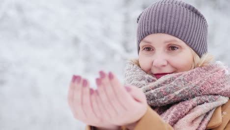 retrato de una mujer en un parque de invierno se regocija en la primera nieve