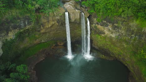 wide aerial dolly backwards to reveal the pool formation at opaekaa falls, hawaii