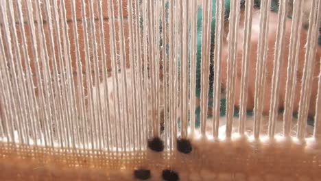 close up on a moroccan girl weaving a carpet with a manual waving machine, carpet weaving , needlework , morocco