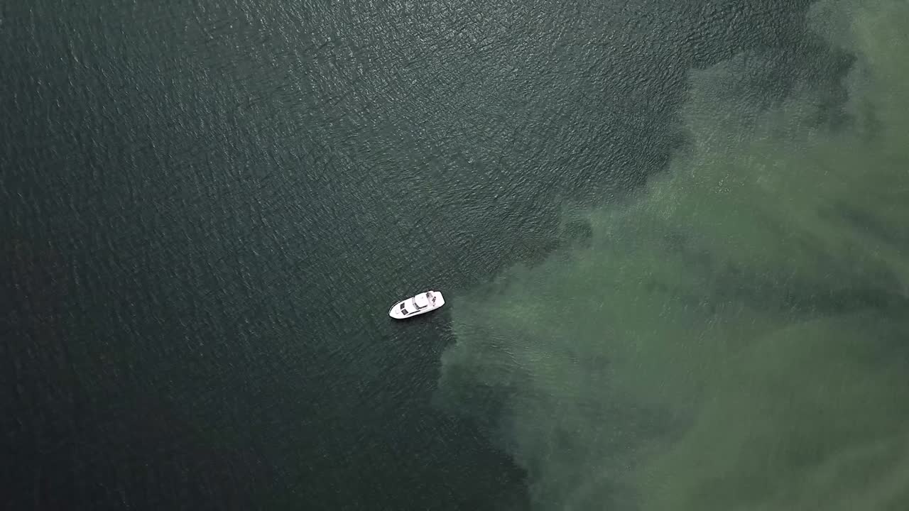 Yacht che naviga sul mare blu poco profondo a Tacoma, Washington durante la bassa marea - vista dall'alto al rallentatore