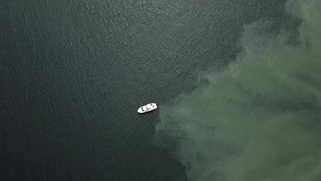 Yacht-Sailing-Over-The-Shallow-Blue-Sea-In-Tacoma,-Washington-During-Low-Tide---top-view-slowmo