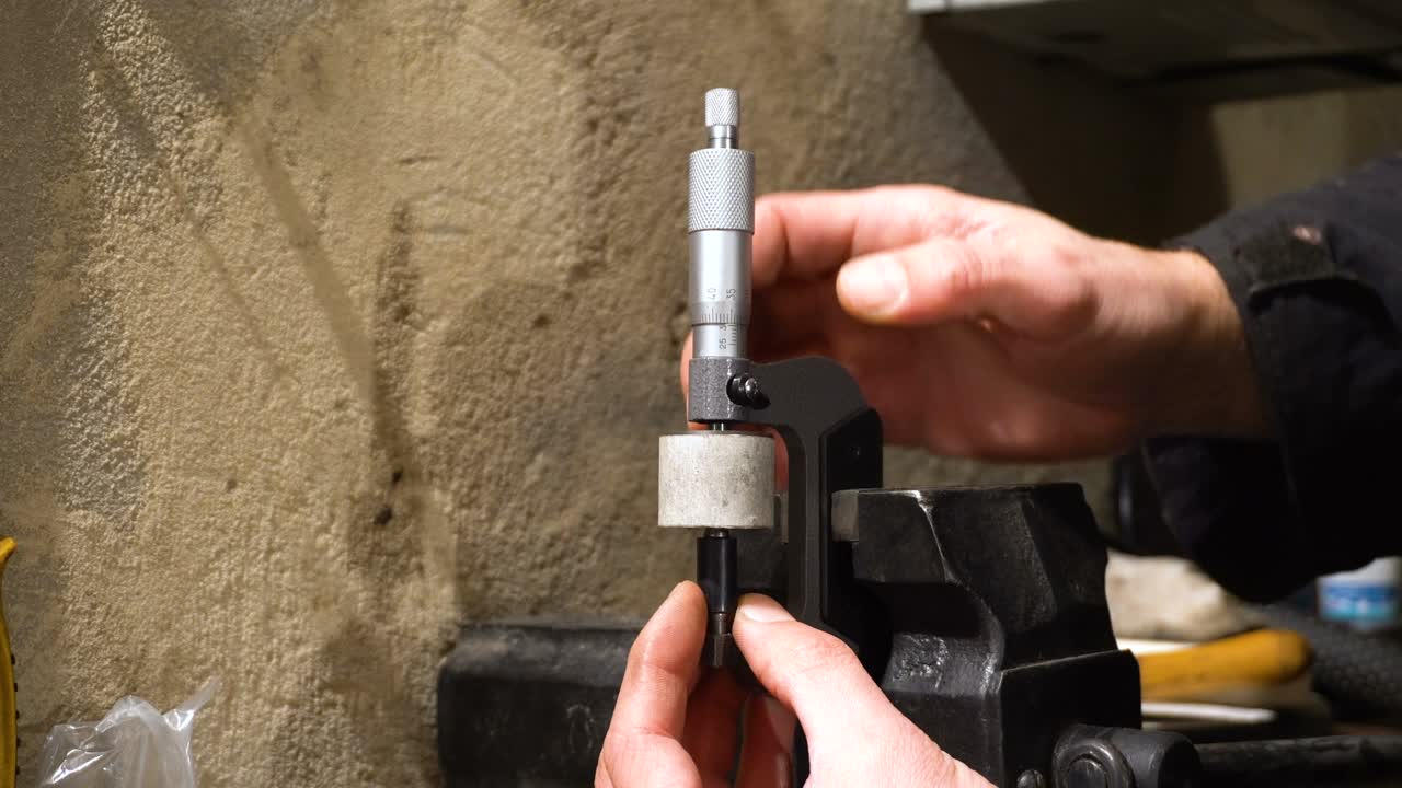 el hombre mide la parte del motor. herramienta de micrómetro