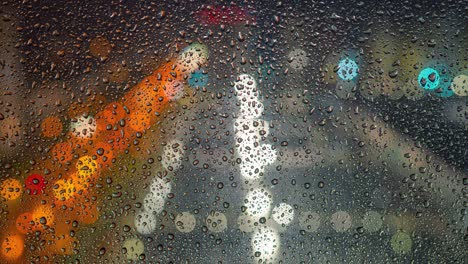 the rain drops flow down the glass on a background of city lights. time lapse