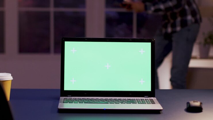 Laptop mit grünem Bildschirm auf einem Schreibtisch