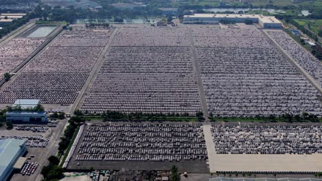massive inventory of unsold cars parked at an open warehouse beside hyundai motors india manufacturing plant in chennai, aerial