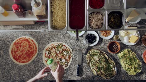 chef anónimo aderezando pizza con hierbas aromáticas