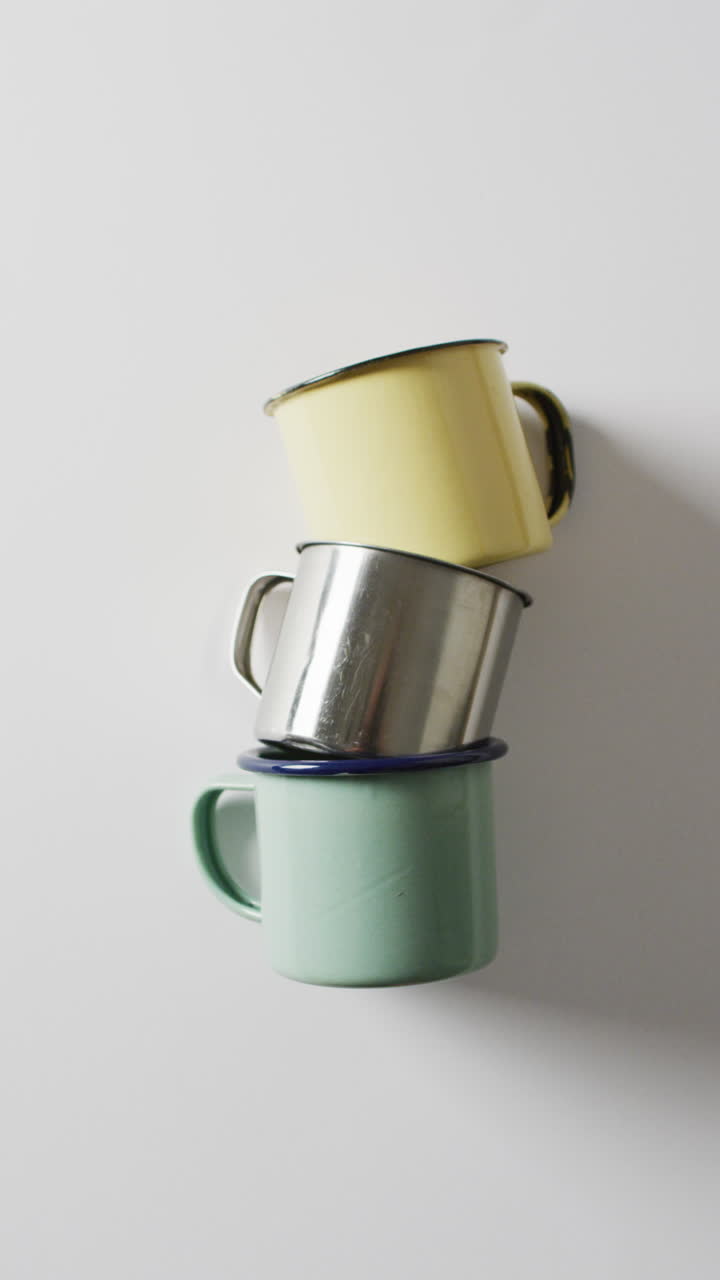 Vertical video of camping equipment with mugs and copy space on white background