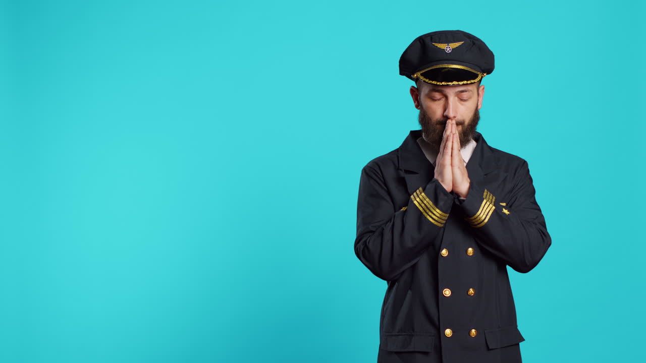 Spiritual aircrew captain praying to god in studio