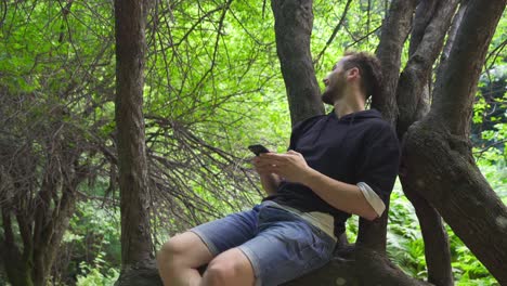 el joven está sentado en el árbol.
