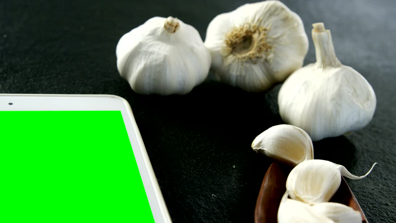검은 바탕에 디지털 태블릿과 함께 마늘 4k