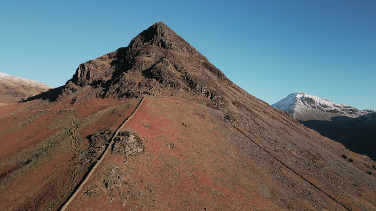 montaña en invierno con pico puntiagudo y montañas nevadas en el fondo en el distrito del lago wasdale uk
