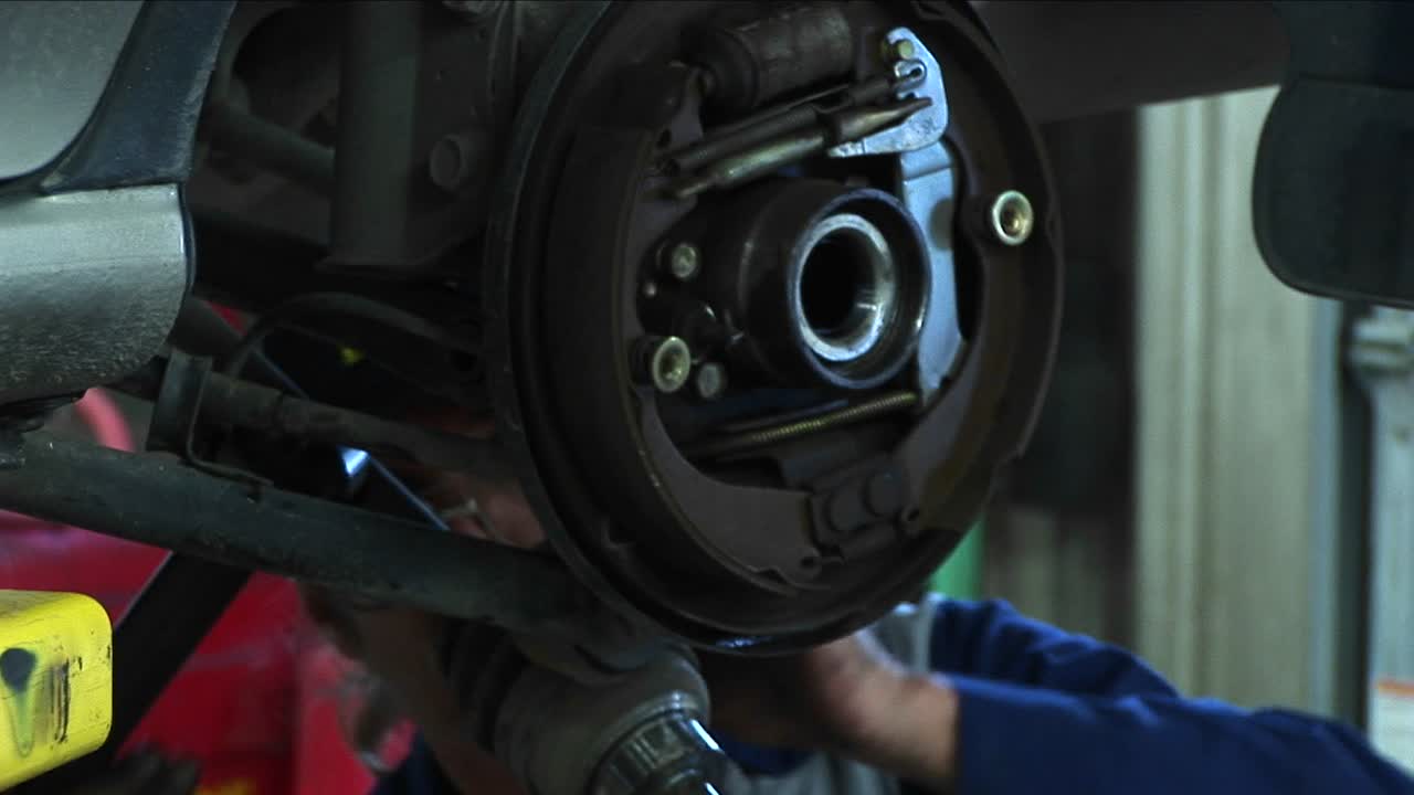 primer plano de un mecánico que trabaja en una reparación de ruedas