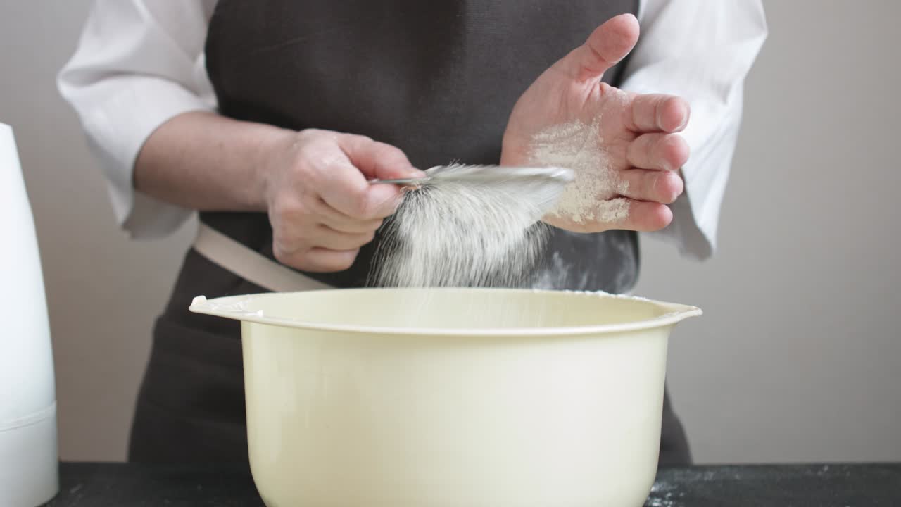 Female hands sifts the flour