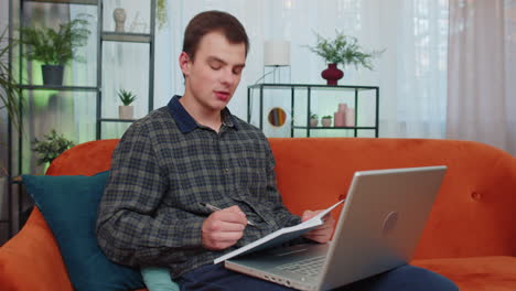 Teenager-man-student-study-at-home-on-laptop-computer-making-conference-video-call-talking-to-webcam