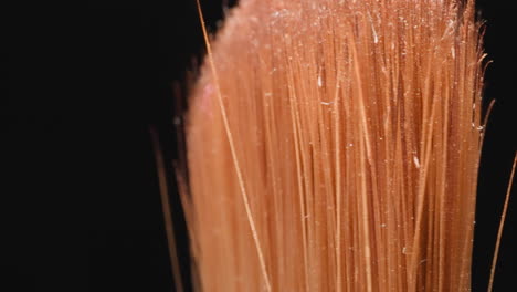 Orange-bristles-of-used-cosmetic-brush-with-glitter-on-top