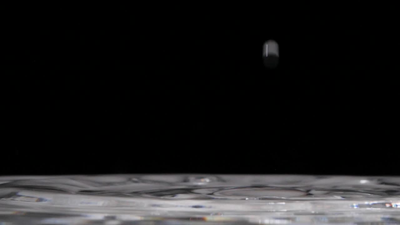 espacio de copia por gota de agua que rebota de tensión superficial, fondo negro de primer plano