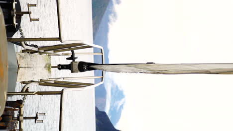 Bow-view-of-luxury-sailboat-while-sailing-in-Fiordland-National-Park,-vertical-view