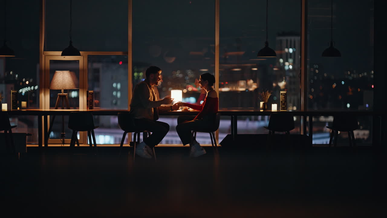 A Couple Enjoying a Romantic Date Night at a Restaurant with City View