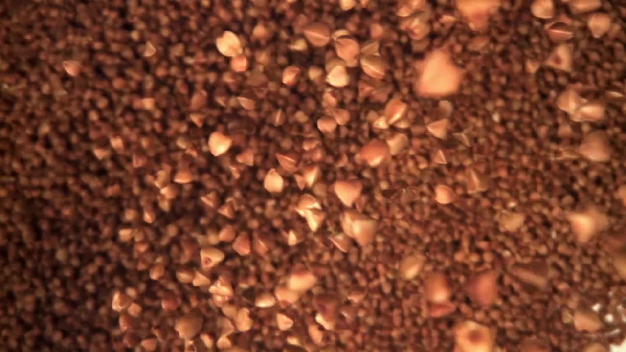 Primo piano di chicchi di grano saraceno che cadono e si muovono