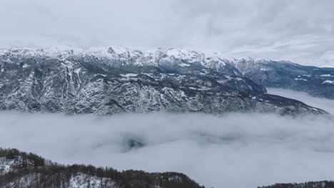 snowy vogel mountain range and sea of clouds during winter. - aerial shot