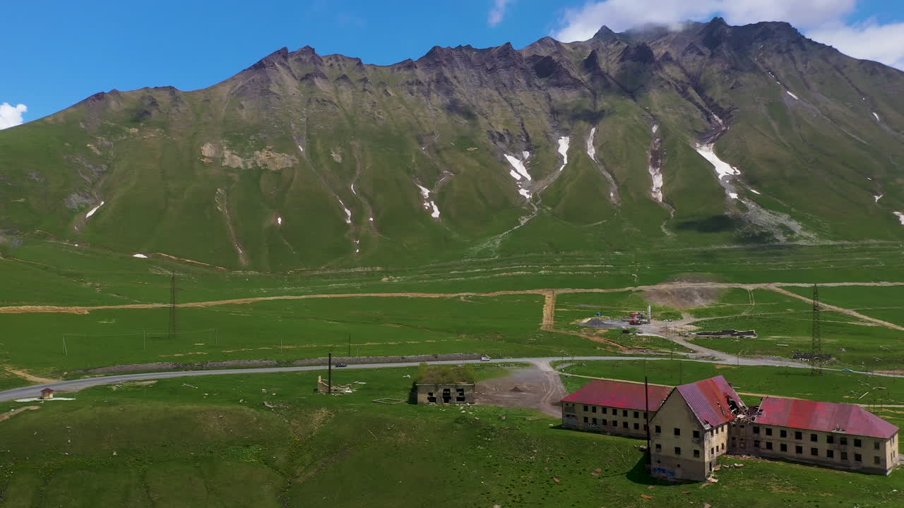 amplia toma de drones de la carretera y el edificio abandonado en gudauri georgia