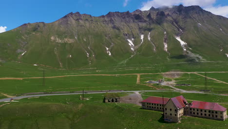 Wide-drone-shot-of-highway-and-abandoned-building-in-Gudauri-Georgia