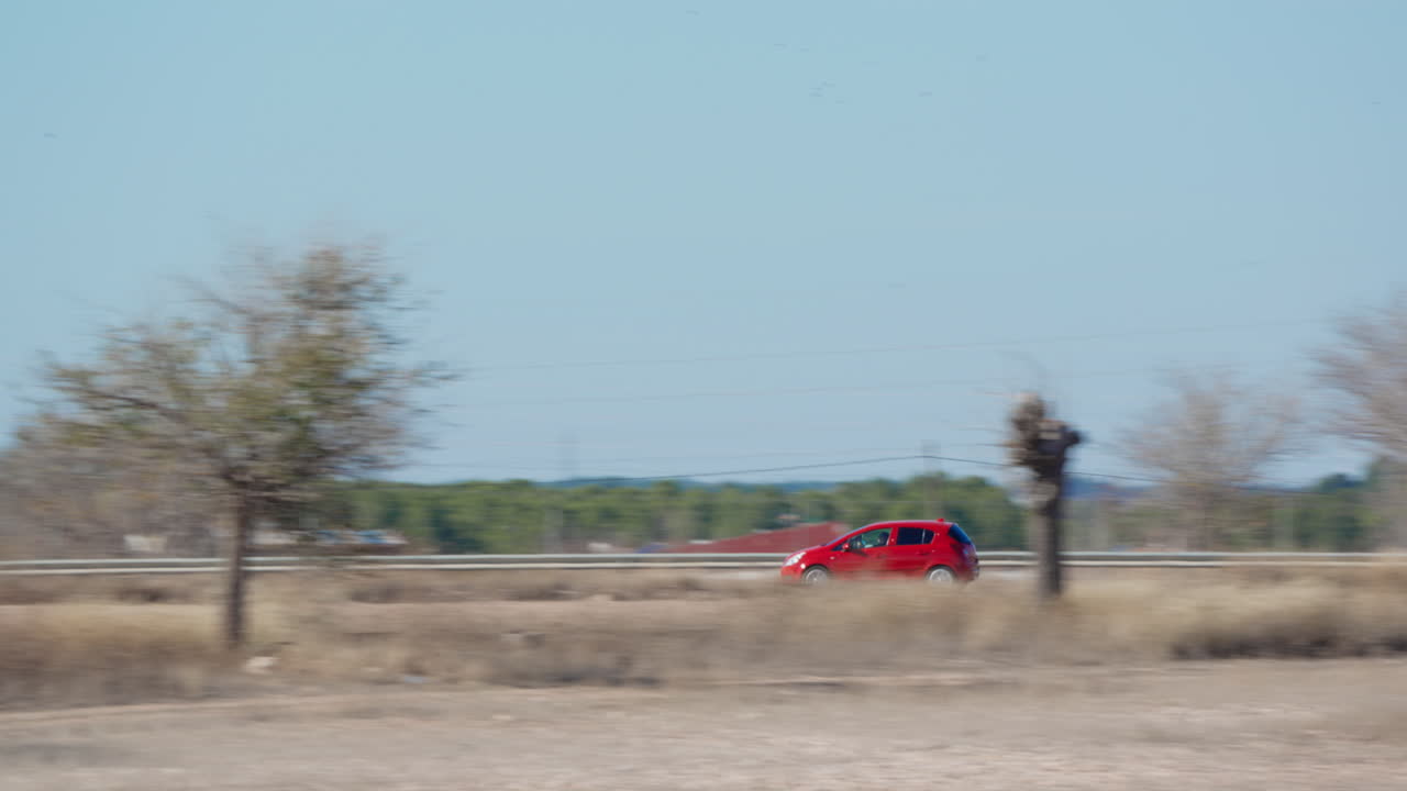 Carro Vermelho Dirigindo em Estrada Rural em Dia Ensolarado