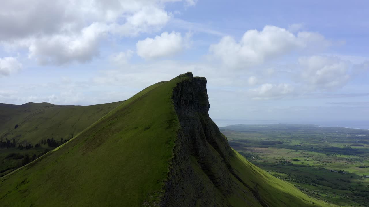 Benwiskin Mountain, Sligo, Ireland, June 2021. Drone orbits the southwestern face revealing magnificent sheer cliffs with Benbulbin in the distance.