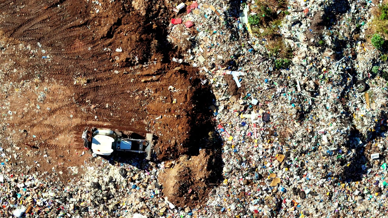 Pala caricatrice frontale sposta detriti in una grande discarica, tema ambientale.