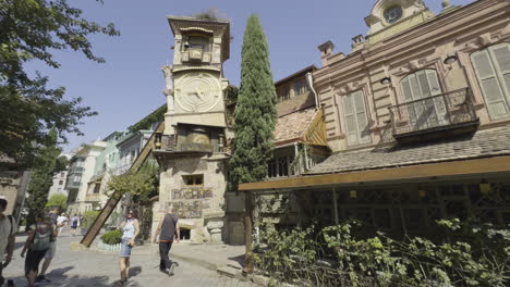 establishing view of the leaning clock tower in tbilisi, georgia, surrounded by the city's old town and architecture