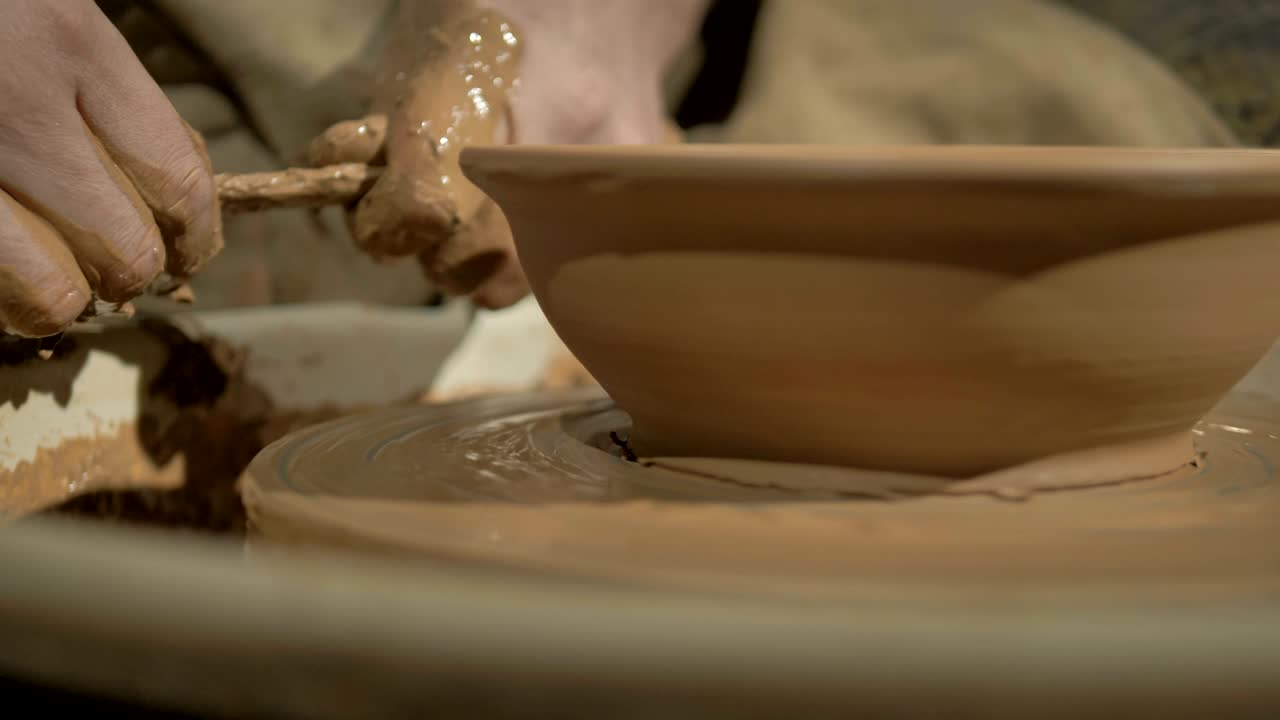 manos de alfareros masculinos haciendo un cuenco en una rueda.