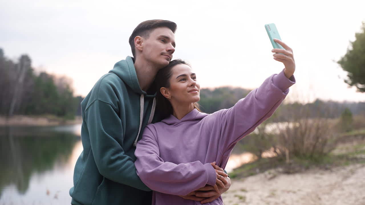 pareja tomando selfies en el bosque