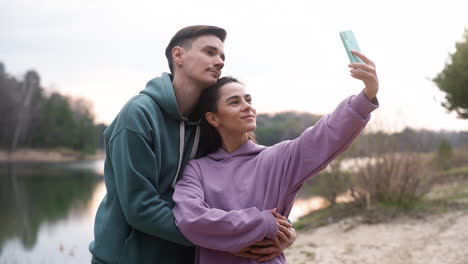 couple taking selfies in the forest