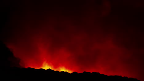 timelapse of a huge red and smoky wildfire in the mountains at night